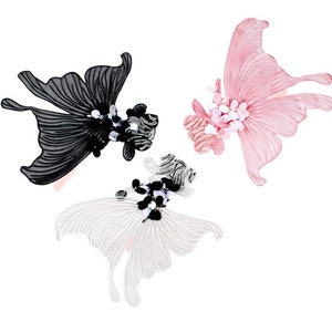Pode incluir: Três apliques decorativos de borboleta em preto, branco e rosa. Cada borboleta apresenta padrões de asas detalhados e é adornada com contas e lantejoulas. Ideal para adicionar um toque de elegância a roupas ou acessórios.