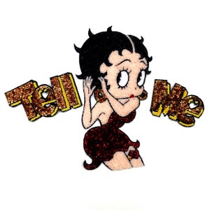 以下が含まれることがあります： 「Tell Me」という文字が両側に書かれた、漫画のキャラクターが描かれた赤と金のラメのアイロン接着パッチです。