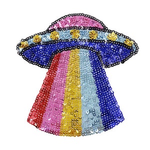 Può includere: Un toppa termoadesiva con paillettes colorate che presenta un UFO color arcobaleno con un design blu, rosa e oro.