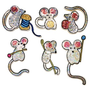Puede incluir: Seis parches de ratón de lentejuelas plateadas brillantes con detalles coloridos. Los ratones sostienen hilo, agujas y una bobina de hilo.