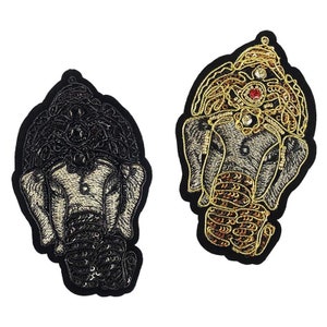May include: Two embroidered patches of the Hindu deity Ganesha, one in black and gold and the other in gold and brown. Both patches feature intricate details and embellishments.
