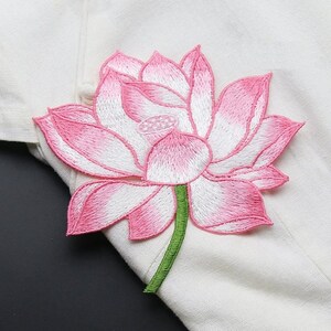 May include: Pink and white embroidered lotus flower patch with a green stem. The patch is perfect for adding a touch of nature to clothing, bags, or other crafts.