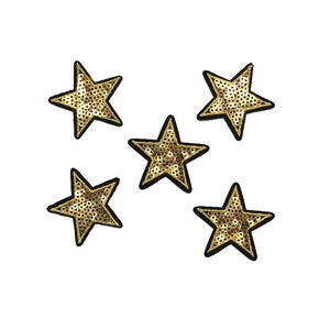 May include: Five gold sequined star patches with black borders on a white background. The stars are arranged in different directions, highlighting their shimmering, textured surfaces. These patches are suitable for adding decoration to clothing or accessories.