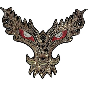 May include: A gold and black sequined appliqué with red eyes. The appliqué is shaped like a stylised face with wings.