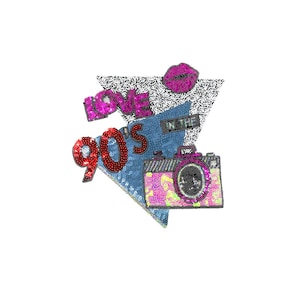Può includere: Un design con paillettes raffigurante una macchina fotografica, labbra e le parole "LOVE 90'S" su sfondo bianco. La fotocamera è rosa e gialla, le labbra sono rosa e il testo è rosso e rosa. Il design è ambientato su un triangolo in denim e bianco e nero.