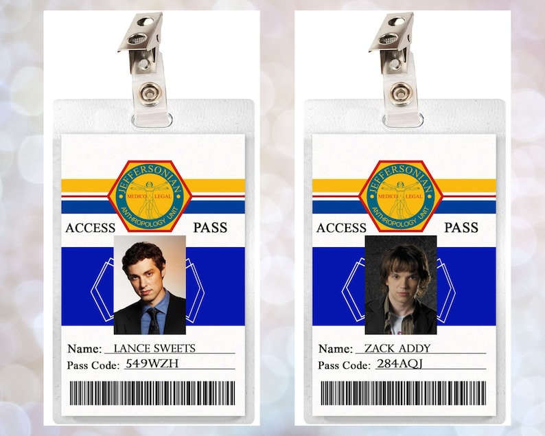 May include: Two white plastic ID badges with blue and yellow accents. The badges have a picture of a person, a name, and a pass code. The text on the badges reads "Jeffersonian Medico Legal Anthropology Unit" and "Access Pass".