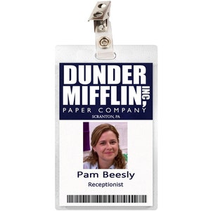 May include: A white plastic ID card with a blue and white logo that says "Dunder Mifflin, Inc. Paper Company Scranton, PA". A photo of a woman with brown hair is in the center of the card. The text "Pam Beesly Receptionist" is below the photo.