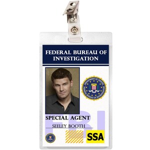 May include: A white plastic ID card with a blue border and the text "Federal Bureau of Investigation" printed on it. A photo of a man with brown hair is in the upper left corner. The text "Special Agent Seeley Booth" is printed below the photo. The seal of the FBI is in the upper right corner. The text "FBI" is printed in blue on a white background in the lower left corner. The text "SSA" is printed in yellow on a black background in the lower right corner.