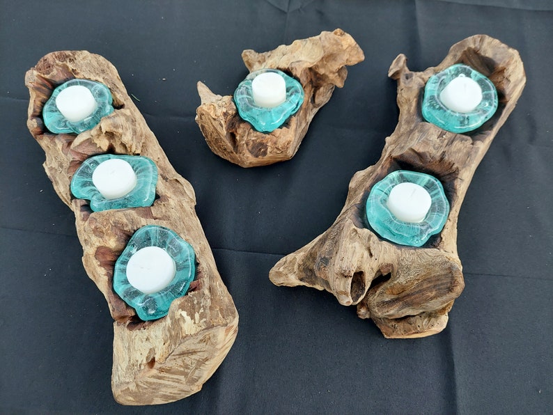 Pode incluir: Tr&ecirc;s casti&ccedil;ais de madeira com copos para velas de vidro turquesa. Os casti&ccedil;ais s&atilde;o feitos de madeira de deriva natural e t&ecirc;m um aspeto r&uacute;stico.