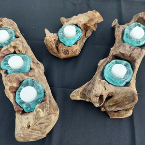 Pode incluir: Tr&ecirc;s casti&ccedil;ais de madeira com copos para velas de vidro turquesa. Os casti&ccedil;ais s&atilde;o feitos de madeira flutuante natural e t&ecirc;m um aspeto r&uacute;stico.