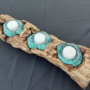 Pode incluir: Um porta-velas de madeira r&uacute;stico com tr&ecirc;s porta-velas de ch&aacute; feitos de vidro transparente. O porta-velas &eacute; perfeito para adicionar um toque de beleza natural a qualquer casa.