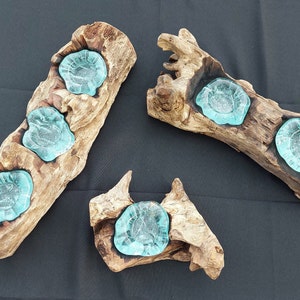 Pode incluir: Tr&ecirc;s casti&ccedil;ais de madeira com inser&ccedil;&otilde;es de vidro azul-turquesa. Os casti&ccedil;ais s&atilde;o feitos de madeira flutuante natural e t&ecirc;m um aspeto r&uacute;stico e org&acirc;nico.