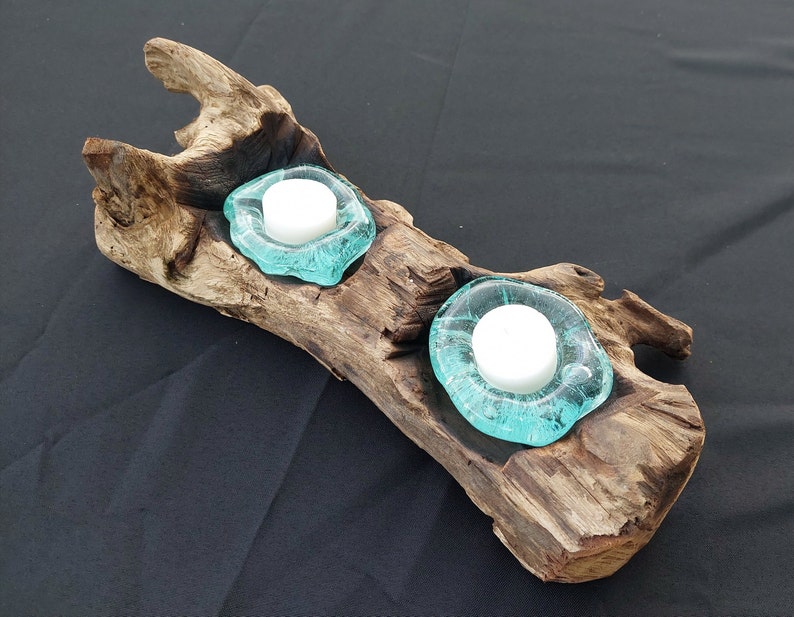 Pode incluir: Um porta-velas de madeira r&uacute;stico com dois copos de vela de vidro azul turquesa. O porta-velas &eacute; feito de madeira flutuante e tem um aspecto natural e desgastado.