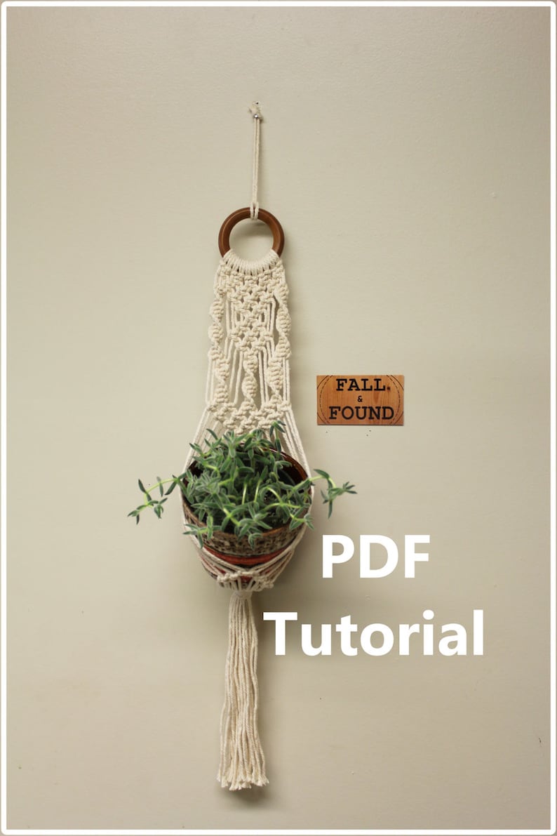 Puede incluir: Un macetero de macram&eacute; blanco con un anillo de madera en la parte superior. El macetero sostiene una peque&ntilde;a maceta de terracota con una planta verde. El texto "FALL & FOUND" est&aacute; en una etiqueta de madera debajo del macetero. El texto "PDF Tutorial" est&aacute; debajo del macetero.