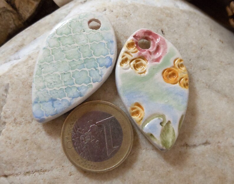 on green and blue background shape drops Set of two ceramic pendants pink and yellow floral motif