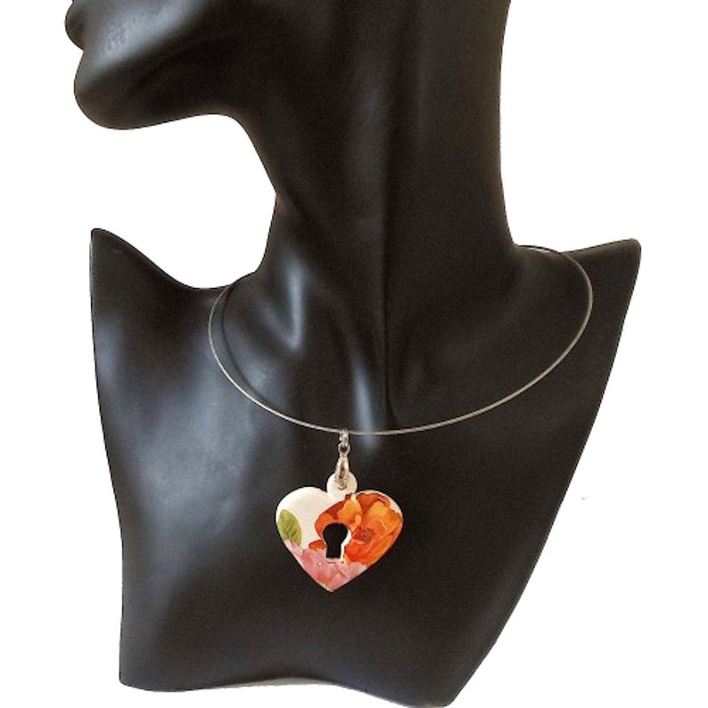 Ceramic pendant heart and key decoration orange pink and green flowers on a white background.
