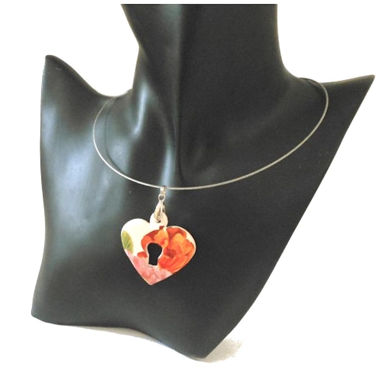 Ceramic pendant heart and key decoration orange pink and green flowers on a white background.