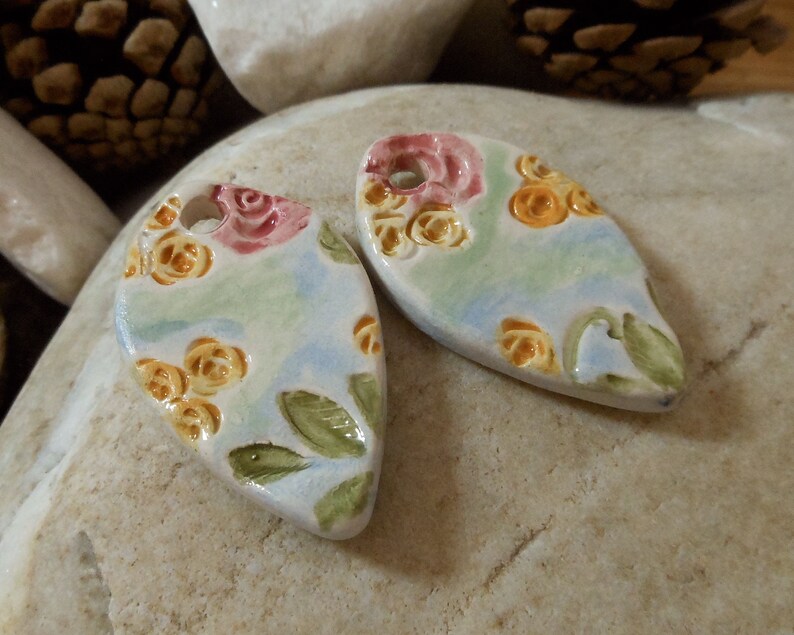 on green and blue background shape drops Set of two ceramic pendants pink and yellow floral motif