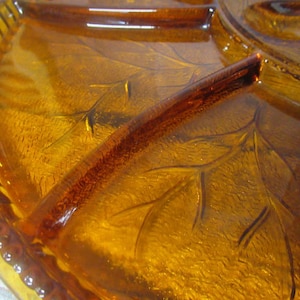 May include: Amber glass serving dish with a decorative leaf pattern and multiple compartments.