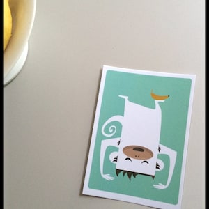 Affenkarte, bunte Postkarte mit Affe und Banane, in den Farben weiß, türkis und gelb