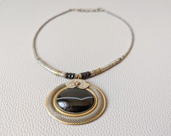 Vintage Langani necklace with large gold and silver colored oval pendant with black stone