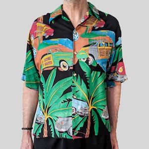 Könnte beinhalten: Ein schwarzes, kurzärmeliges Hemd mit Knöpfen und einem tropischen Druck mit Palmen und Oldtimern. Die Autos sind in den Farben Grün, Gelb, Rot und Blau gehalten.