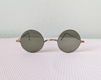 Round, antique sunglasses, "John Lennon glasses" from the 1930s or 1940s with thin metal frame