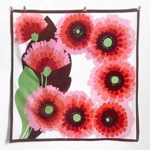 May include: A white square scarf with a brown border and a repeating pattern of pink, red, and green stylized flowers.