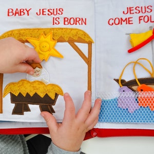 May include: A felt book for children with a yellow star, a manger scene with baby Jesus, and a blue net with two fish. The text on the book reads "Baby Jesus is born" and "Jesus said come follow".