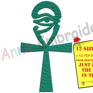 May include: A teal embroidered Ankh symbol, a cross with a loop at the top, on a white background. A yellow sticky note with text about design sizes and guidelines is pinned to the right. A white top hat with stars is on the left.
