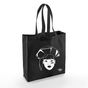 May include: Black tote bag with a white illustration of a woman wearing a hat and a black eye patch. The text "=MAD= LIFE" is printed on the bag.