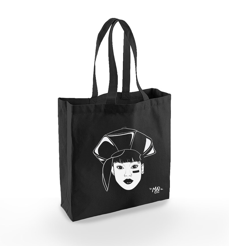 May include: Black tote bag with a white illustration of a woman wearing a hat and a black eye patch. The text "=MAD= LIFE" is printed on the bag.