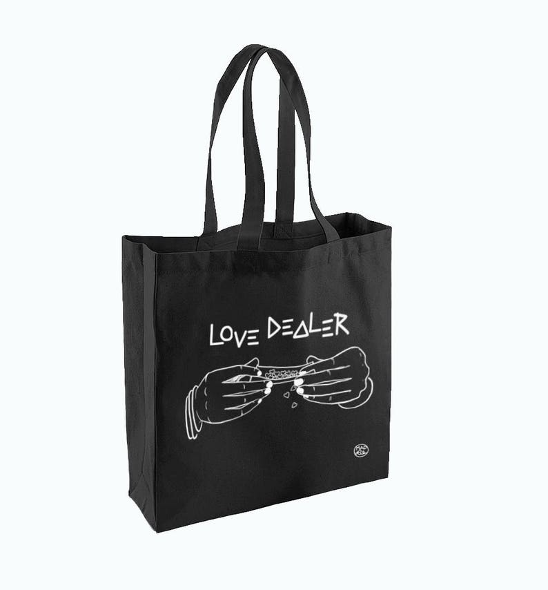 May include: Black canvas tote bag with white text that reads "LOVE DEALER" and a graphic of two hands rolling a joint.