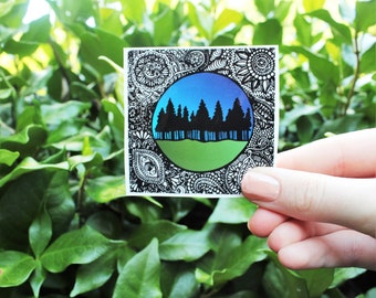 May include: A black and white sticker with a mandala design. The center of the mandala is a circle with a blue and green gradient. Inside the circle are black silhouettes of trees.