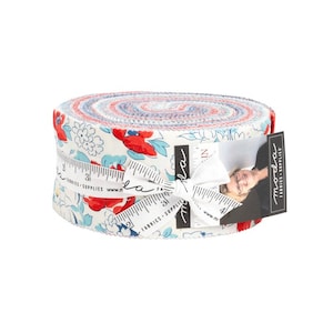 May include: Rolled fabric bundle featuring a floral pattern with red, blue, and white flowers on a cream background. The fabric is tied with a white ribbon and a tag that reads "moda fabrics + supplies".