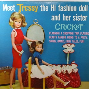 May include: A vintage record album cover featuring two dolls, Tressy and Cricket. The cover is blue with white text and a red and white polka dot design. The text reads "Meet Tressy the Hi fashion doll and her sister Cricket."  "Planning a shopping trip, playing beauty parlor, going to a party, songs, games, fairy tales, fun!" and "Majorette Records".