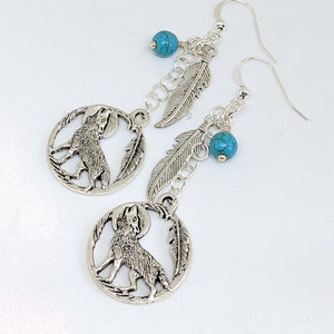 May include: Silver earrings with a howling wolf charm, turquoise beads, and feather accents.