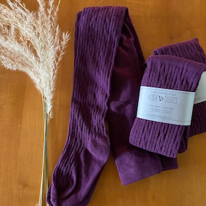 May include: Purple cable knit tights with a white label that reads "Rosie Creek Boutique Rosie Tights Hand dyed cable knit 100% superwash merino wool rosiecreekboutique.etsy.com"