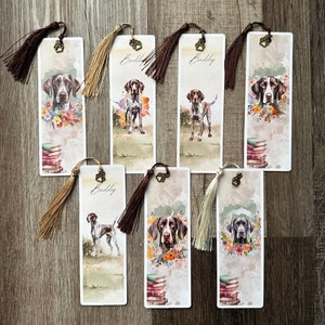May include: Set of eight watercolour bookmarks featuring a brown and white dog breed with a stack of books and the word "Birddog" printed on each bookmark.