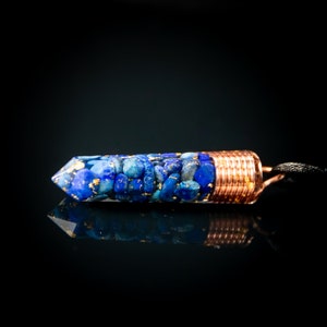 May include: A copper-wrapped pendant with a pointed end filled with blue and gold lapis lazuli stones.