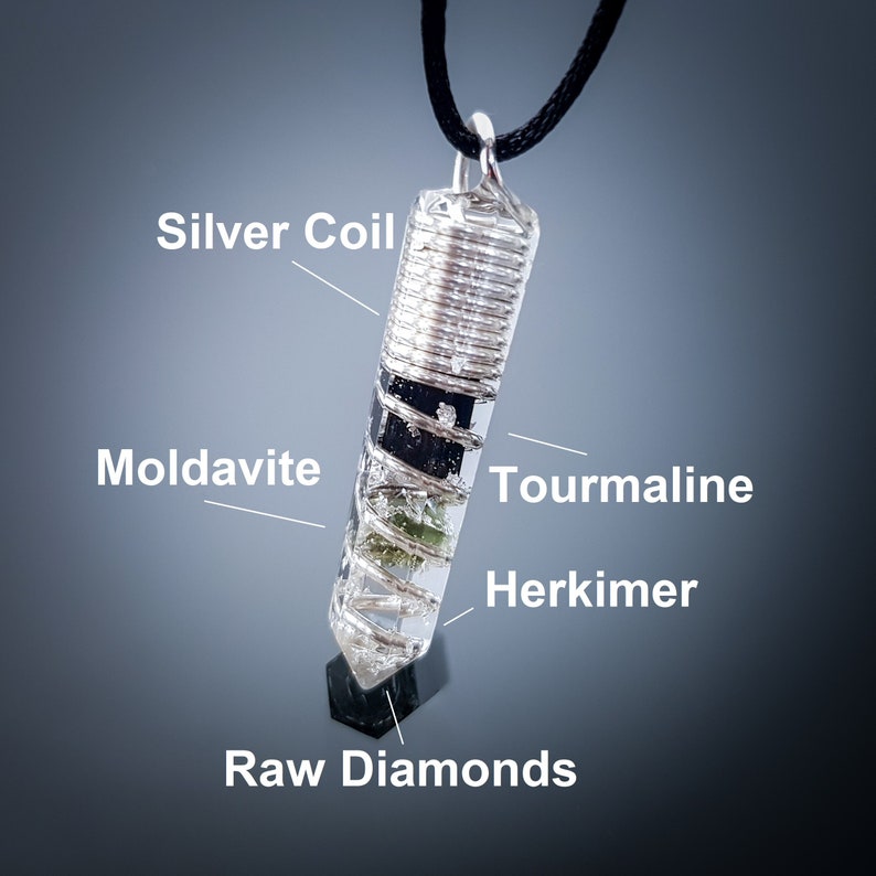 May include: A silver coil pendant with a clear crystal filled with various crystals, including moldavite, tourmaline, herkimer, and raw diamonds.