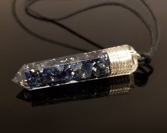May include: A silver wire-wrapped pendant with a clear resin point filled with blue and silver glitter. The pendant is attached to a black cord.