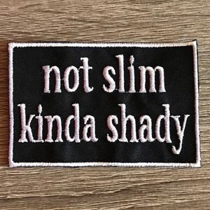 May include: Black embroidered patch with white text that reads "not slim kinda shady".