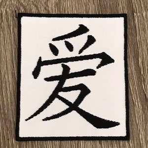 May include: White patch with black embroidered kanji characters that read "love" in Japanese.