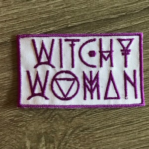 May include: White embroidered patch with purple stitching. The patch says "Witchy Woman" with various symbols and designs.