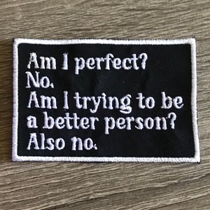 May include: Black embroidered patch with white text that reads "Am I perfect? No. Am I trying to be a better person? Also no."