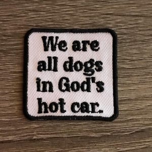 May include: White embroidered patch with black text that reads "We are all dogs in God's hot car."
