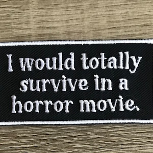 May include: Black embroidered patch with white stitching. The patch reads "I would totally survive in a horror movie."