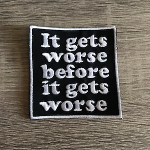 May include: Black embroidered patch with white text that reads "It gets worse before it gets worse".