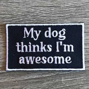 May include: Black and white embroidered patch with white text that reads "My dog thinks I'm awesome".